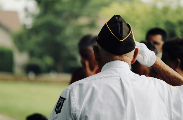 elderly veteran seen from the back, saluting